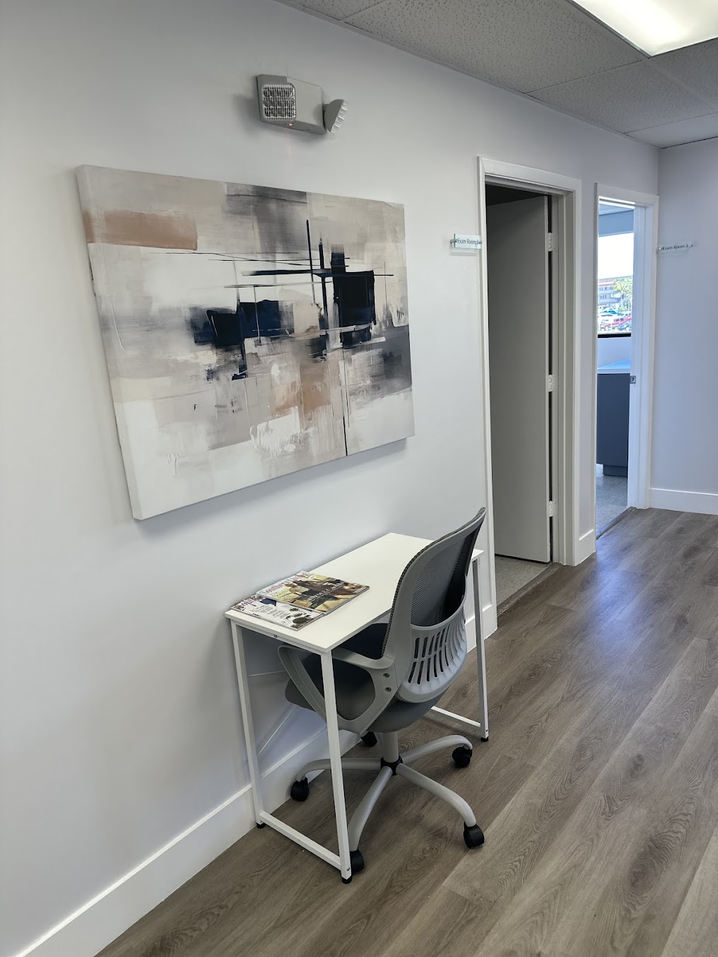 Clinic hallway with contemporary artwork and hardwood floor